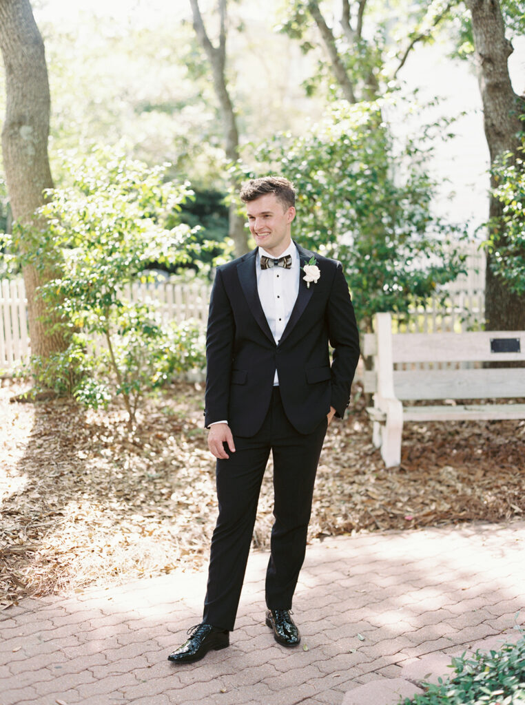 groom poses in garden wedding at carillon 