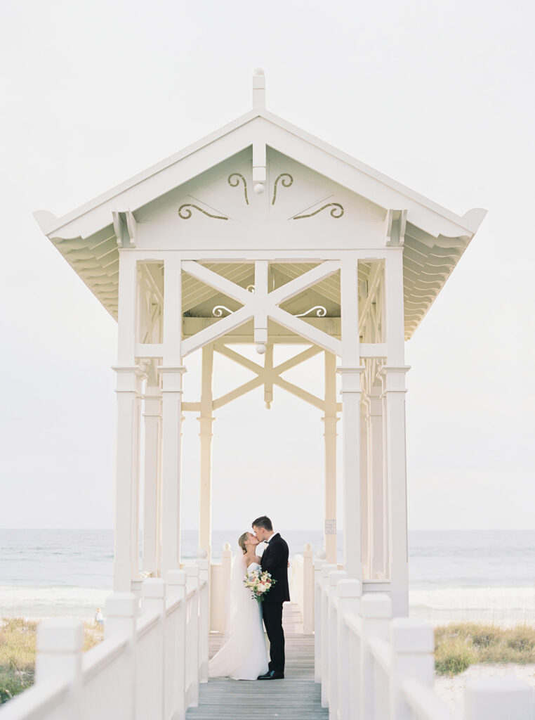 posing under an archway near the beach at garden wedding at carillon 