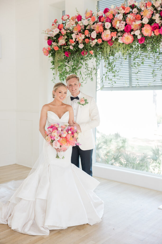 bride and groom pose together under gorgeous floral details at carillon wedding