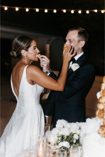 feeding each other cake at seaside wedding