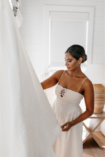 bride looking at her dress before her seaside wedding at the court