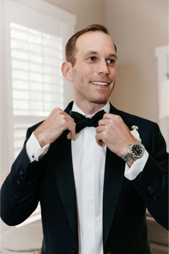 groom adjusting his bow tie