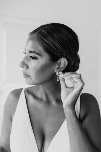 bride getting on her earrings before the big day