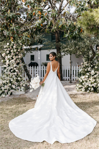 bride under floral archway in her beautiful dress